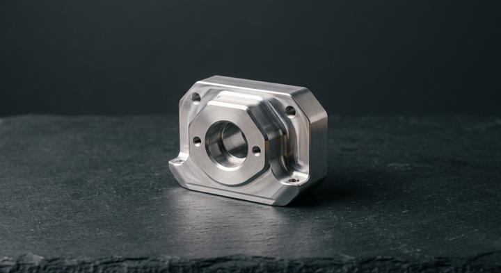 Minimalist precision-engineered metal prototype component highlighting clean edges and complex stamping geometries.