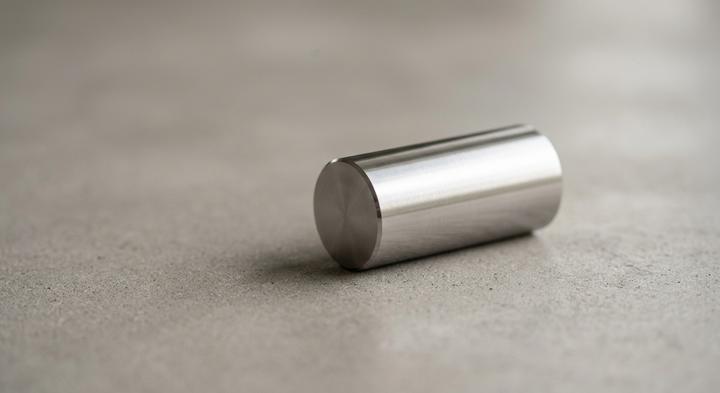 Minimalist macro shot of a polished metallic cylinder highlighting material precision and tool steel quality.