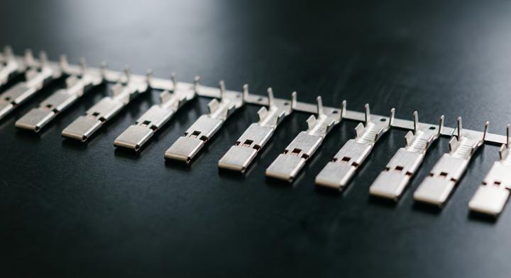 Clean stamped metal components aligned precisely on a dark reflective surface