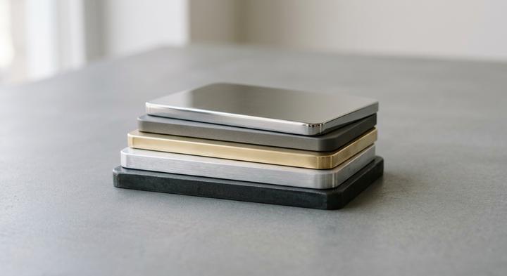 A minimalist arrangement of pristine metal alloy plates under soft lighting.