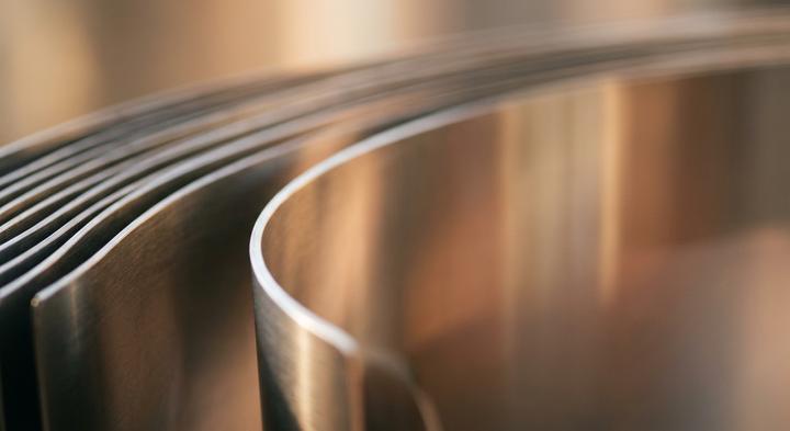 Abstract close-up of parallel metal sheets with soft light reflection.