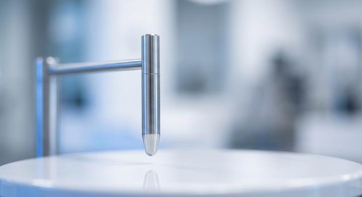 Sleek calibration probe tip in a sterile quality control metrology lab environment.