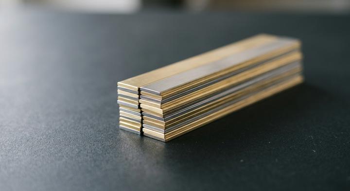 Precision-cut metallic strips in a minimal industrial setting representing high-quality stamping materials.