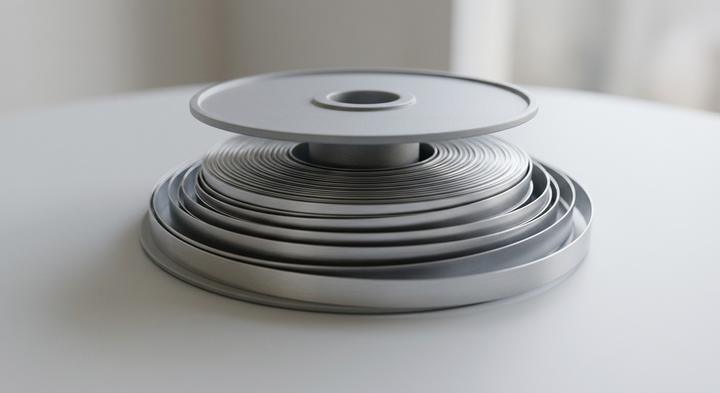 Abstract 3D render of a continuous metallic carrier tape winding neatly
